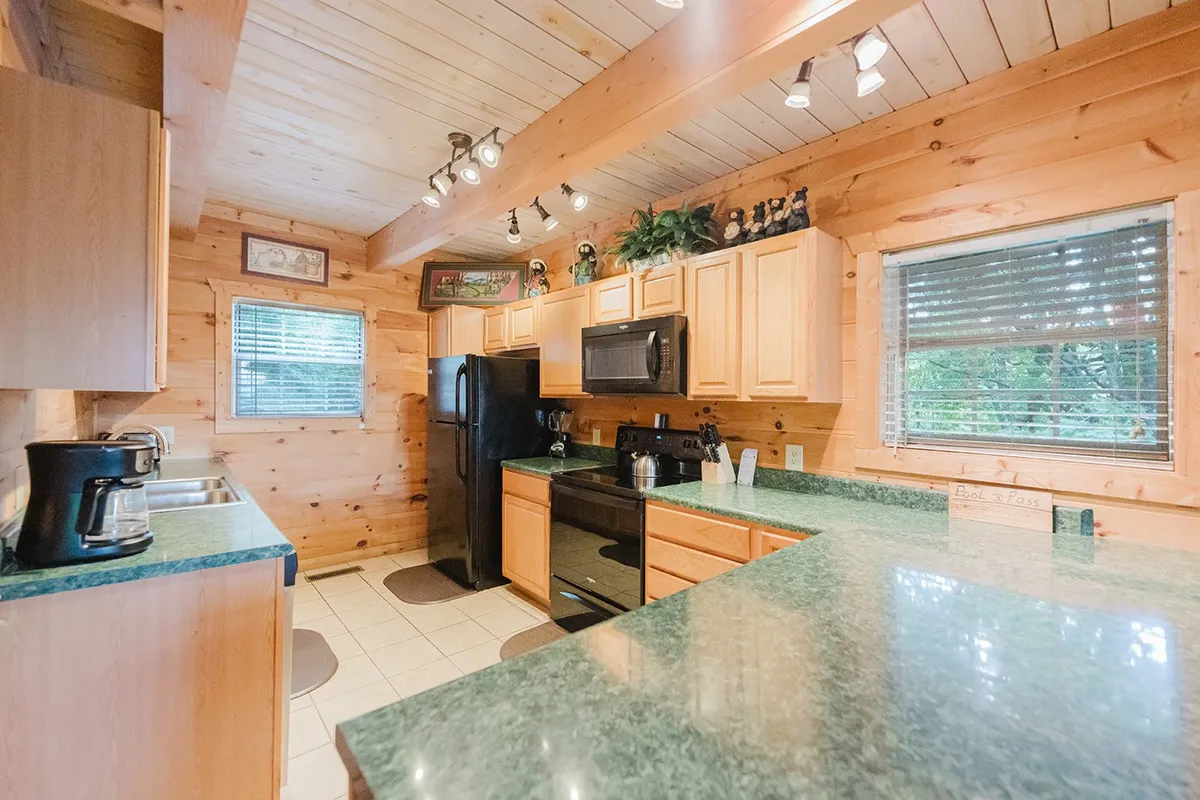 A well-equipped kitchen with a large island, sleek appliances, and wooden cabinetry. The space is designed for both cooking and casual conversations, with plenty of countertop space for meal prep or serving snacks.